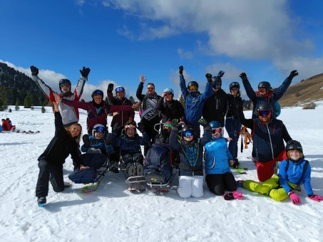 Gruppenbild von 17 Personen in Skikleidung im Schnee.